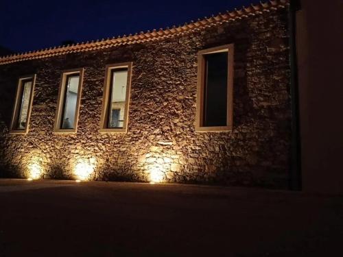 a building with lights on the side of it at night at Raízes Turismo Rural in Castelo Branco
