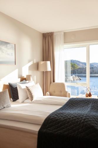 a hotel room with two beds and a large window at Lindesnes Havhotel in Spangereid