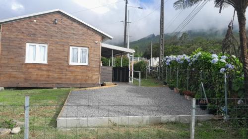 a house with a staircase next to a house with flowers at Le Piton des Roches in La Plaine des Palmistes