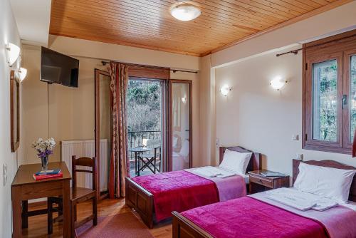 a hotel room with two beds and a window at Xenonas Kypseli in Kipseli