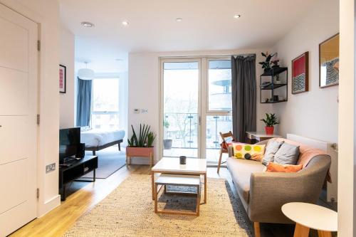 a living room with a couch and a table at Pass the Keys Cosy Studio flat with a Balcony in London