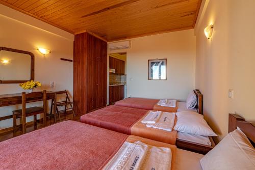 a bedroom with two beds and a desk and a table at Xenonas Kypseli in Kipseli