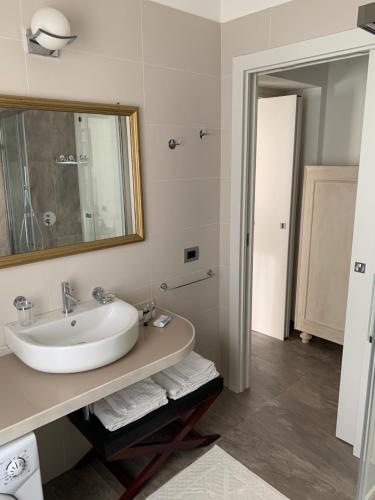 a white bathroom with a sink and a mirror at PAVIA CENTRO in Pavia