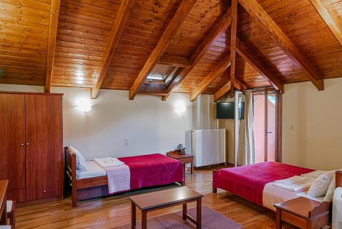 a room with two beds in a room with wooden ceilings at Xenonas Kypseli in Kipseli