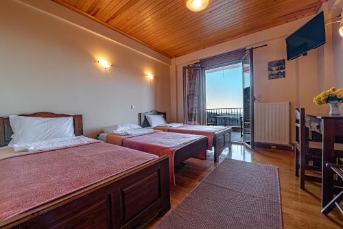 a hotel room with two beds and a balcony at Xenonas Kypseli in Kypséli