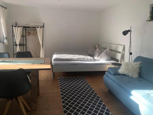 een slaapkamer met een bed, een tafel en een bank bij 1 ZI Appartement Zauberwald in Bildstein