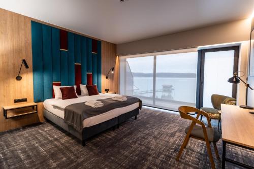 a hotel room with a bed and a large window at OTTON-Charzykowy Bed&Restaurant in Chojnice