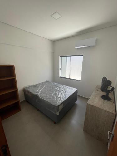 Cette chambre blanche dispose d'un lit et d'une fenêtre. dans l'établissement Casa a 40 metros da praia, rua tranquila, à Penha