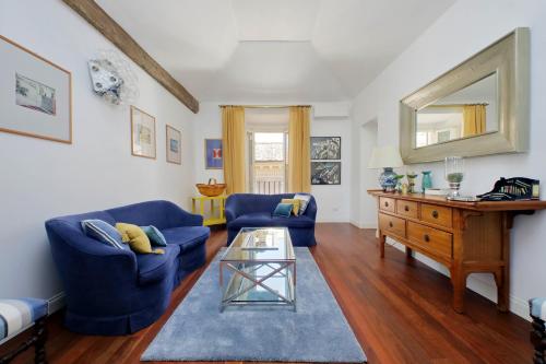 un soggiorno con divani blu e un tavolo in vetro di YCH-Penthouse Fiammetta a Piazza Navona a Roma