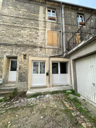 un ancien bâtiment en briques avec deux portes blanches dans l'établissement Caen le port : superbe appartement refait à neuf, à Caen