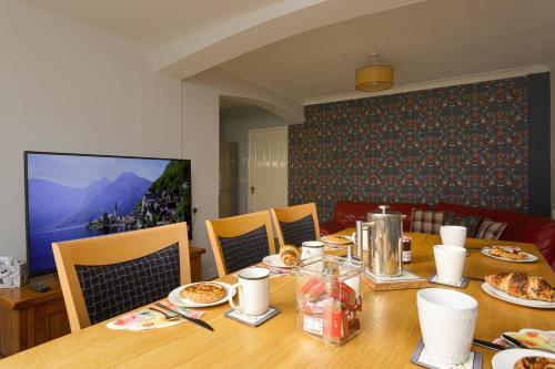 a dining room table with plates of food on it at Blue Sparrow 4 bed House off road PARKING Pet friendly in Portsmouth