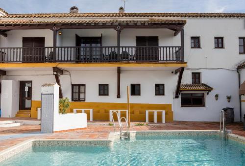 a house with a swimming pool in front of a building at Hotel Tugasa Las Truchas in El Bosque