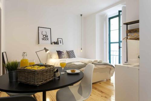 uma sala de estar com uma mesa e um sofá em Urban Design Estudio no Centro com Ar Condicionado em Lisboa