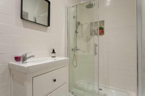 uma casa de banho branca com um lavatório e um chuveiro em Urban Design Estudio no Centro com Ar Condicionado em Lisboa
