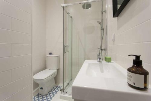 uma casa de banho com um WC, um lavatório e um chuveiro em Green Centro da Cidade Ar Condicionado em Lisboa