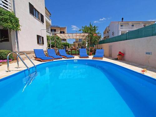 una gran piscina azul con tumbonas en Apartments Zadro, en Tribunj