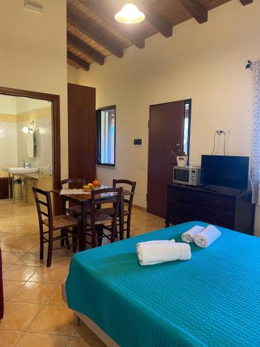 a bedroom with a bed and a table with chairs at La Fontana Dei Desideri in Alghero