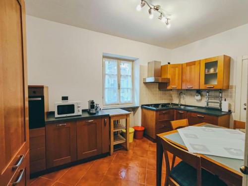 a kitchen with wooden cabinets and a table in it at La finestra sui Cappuccini in Turin