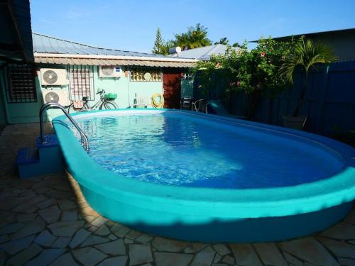 a large blue swimming pool in a yard at Logement privatif avec piscine & barbecue partagés in Kourou