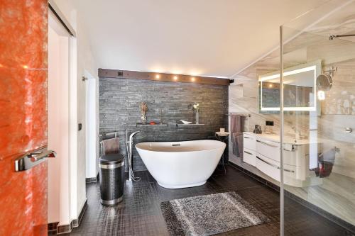 a bathroom with a large tub and a sink at Panoramalodge Rügen in Altefähr