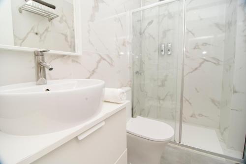 a white bathroom with a sink and a shower at Marinero in La Restinga