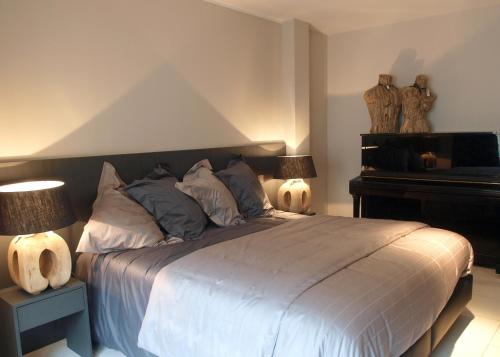 a bedroom with a bed with two lamps and a piano at Private House in Blankenberge