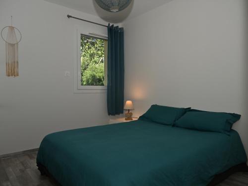 une chambre avec un lit bleu et une fenêtre dans l'établissement Bel appartement moderne au Golf avec terrasse et parking - FR-1-165A-102, à Barcelonnette
