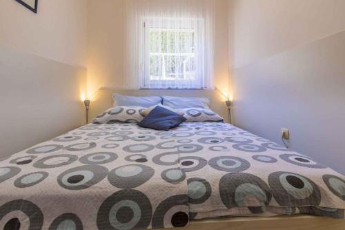 um quarto com uma cama grande, 2 almofadas e uma janela em One-Bedroom Apartment in Crikvenica XVI em Dramalj
