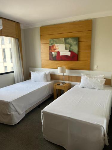 um quarto de hotel com duas camas e uma janela em Flat maravilhoso em frente aeroporto de Congonhas Nobile em São Paulo