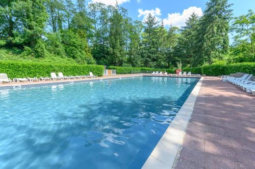 une grande piscine avec des chaises et des arbres dans l'établissement MOBIL HOME LE JACKSON 2, à Mirgaudon