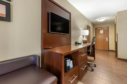 a hotel room with a desk and a tv at Comfort Suites Bridgeport - Clarksburg in Bridgeport