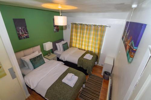 um pequeno quarto com 2 camas e um sofá em Allen Wednesbury Accommodation em Darlaston
