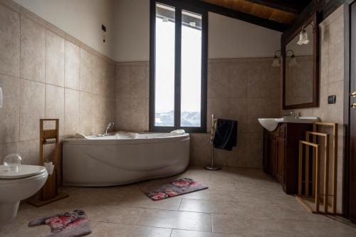 ein Badezimmer mit einer Badewanne, einem Waschbecken und einem WC in der Unterkunft Villa Cavalieri in Vedriano in Roncovetro