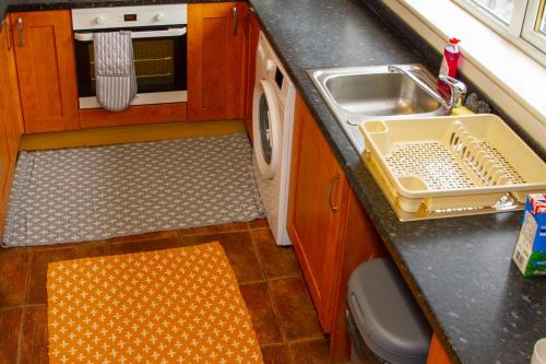 a kitchen with a sink and a washing machine at Allen Wednesbury Accommodation in Darlaston