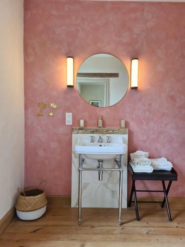 La salle de bains est pourvue d'un lavabo et d'un miroir. dans l'établissement Jardin Meurin, à Tabanac