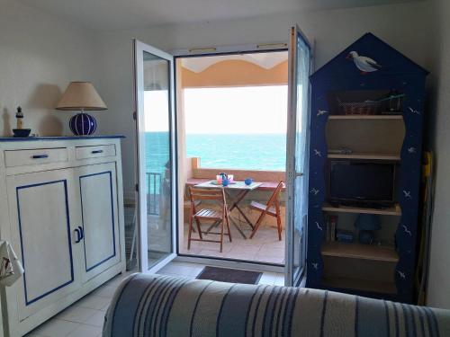 a kitchen with a door open to a balcony with the ocean at 4RB4 Appartement type T2 bord de mer ACCES PLAGE DIRECT in Collioure