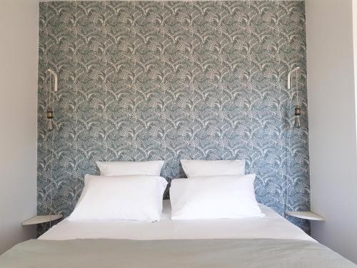a bedroom with a bed with a damask wallpaper at ESCAPADE BELLEPIERRE (L') in Saint-Denis