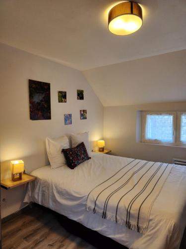 a bedroom with a bed with two lamps on it at Appartement calme Le clos de Renée in Hautvillers