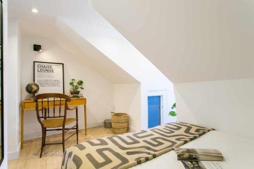 a bedroom with a bed and a table and a chair at Studio Blue LX- 1 de Maio in Lisbon