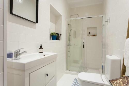 a white bathroom with a sink and a shower at Blue Centro da Cidade Ar Condicionado in Lisbon