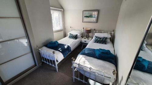 2 camas individuales en una habitación con ventana en Holly Cottage, Hidden gem in the Yorkshire wolds en Welton