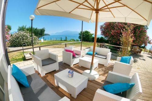 a patio with white chairs and an umbrella at Sivinos Camping Boutique in Manerba del Garda