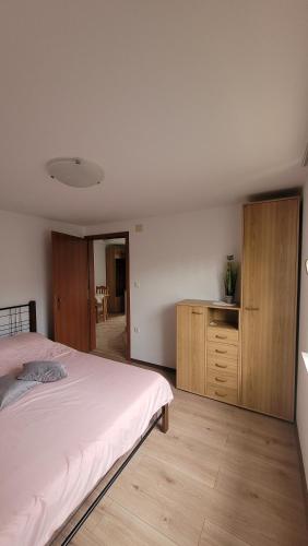 1 dormitorio con 1 cama y armario de madera en Apartma Emilio, en Breginj