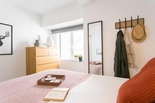 1 dormitorio con cama y espejo en Confortável Apartamento Centro da Cidade Univ, en Lisboa