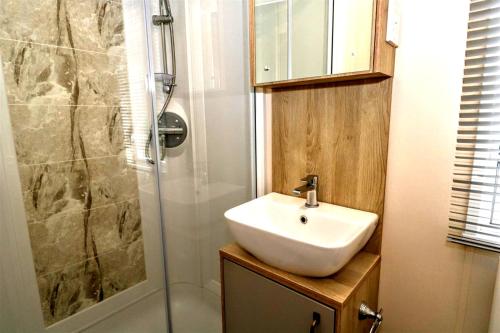ein Bad mit einem Waschbecken und einer Dusche in der Unterkunft Broadway Drive 3 in South Cerney