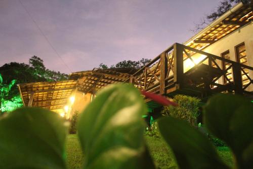 a house with a wooden staircase in a yard at night at Pousada e Bistrô Estância Monte Horebe in Mulungu