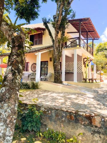 a house with two trees in front of it at Pousada e Bistrô Estância Monte Horebe in Mulungu
