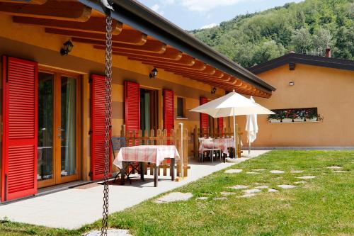 a house with a patio with a table and an umbrella at Agriturismo Terra e Lago d'Iseo Franciacorta in Paratico