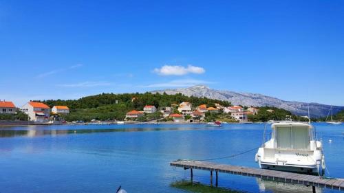 a boat docked at a dock on a lake at Apartments Radojkovic in Lumbarda