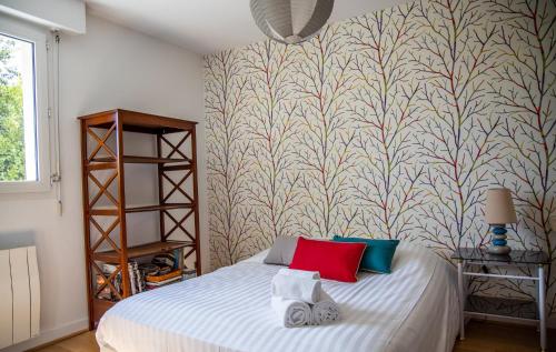 a bedroom with a bed and a wall mural at L'Abstrait - T3 avec parking à 5 minutes du port in Vannes